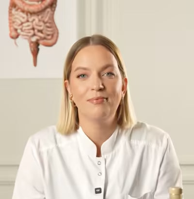 Clinician in a white coat seated in front of an anatomical intestine model