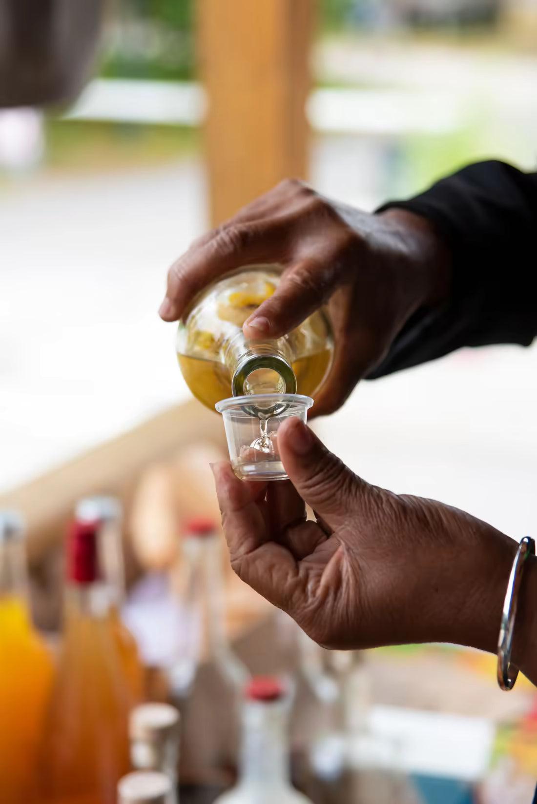 Hands pouring a small daily drink serving