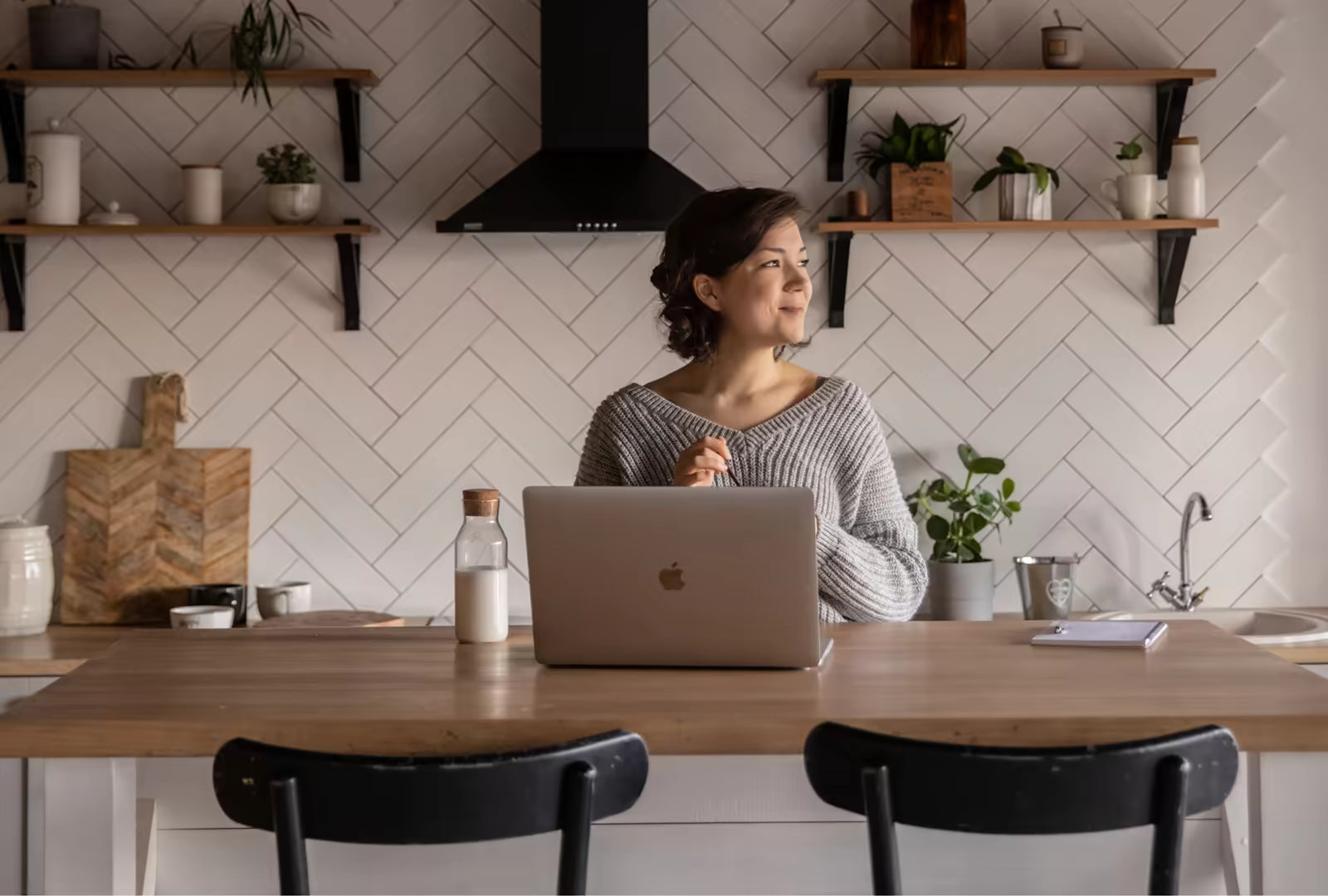 Woman in a kitchen with a laptop at the table