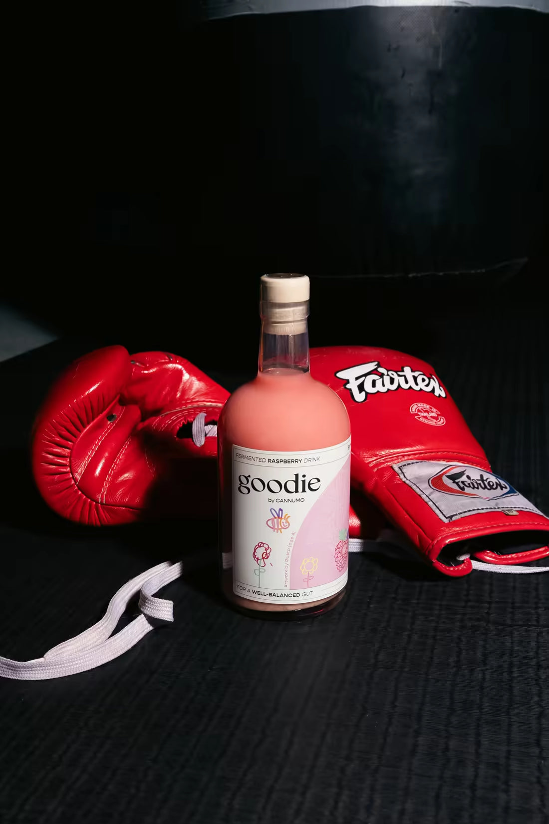 Goodie raspberry fermented drink bottle next to red boxing gloves